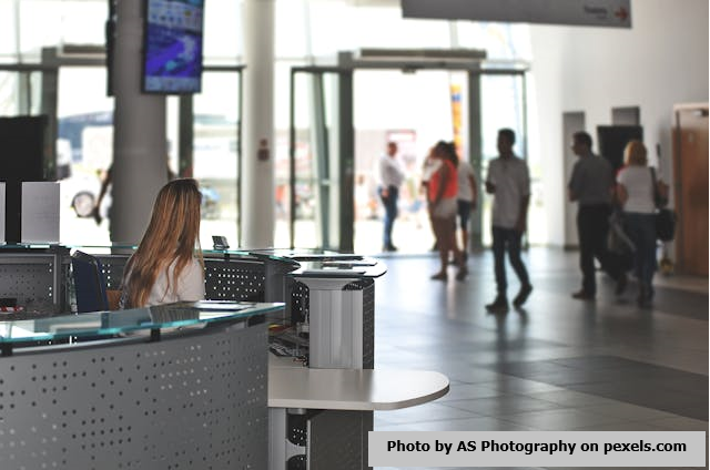 A woman standing behind a counter providing customer service.